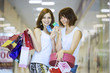 Photo: Two girls with packages show credit cards Two girls with packages show credit cards