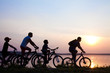 Photo: family on bicycles admiring the sunset on the lake. silhouette family on bicycles admiring the sunset on the lake. silhouette