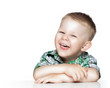 Photo: Portrait of a cute little boy smiling while sitting at table, is Portrait of a cute little boy smiling while sitting at table, is