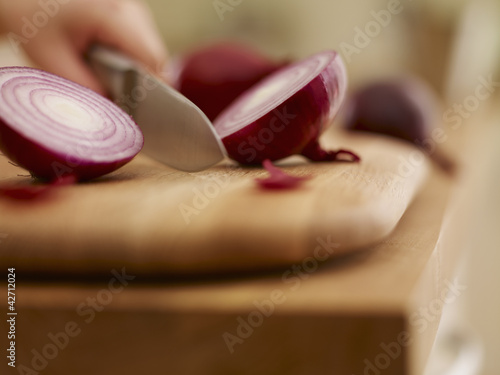 Photo: Knife chopping red onion on cutting board Knife chopping red onion on cutting board