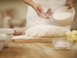 Woman dusting dough with flour