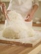 Woman dusting dough with flour