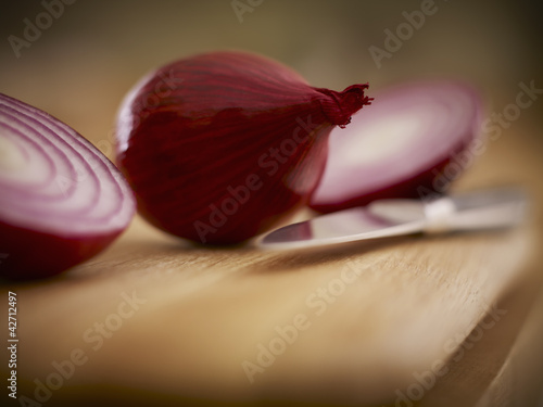 Photo: Close up of red onions and knife on cutting board Close up of red onions and knife on cutting board