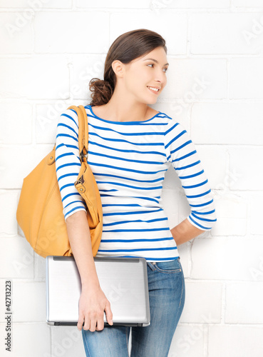 Photo: happy and smiling teenage girl with laptop happy and smiling teenage girl with laptop