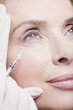 Close up of woman receiving botox injection under eye