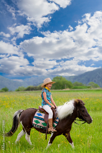 Photo: Horse riding - lovely girl is riding a pony Horse riding - lovely girl is riding a pony