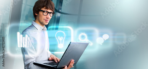 Foto: Business man holding laptop working with virtual interface Business man holding laptop working with virtual interface