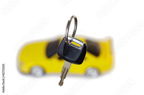 Photo: Key from car close up and yellow car in the background Key from car close up and yellow car in the background