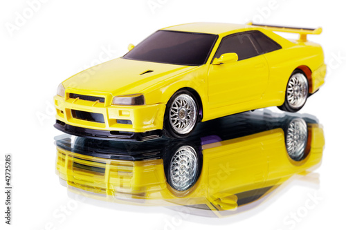 Photo: Yellow toy car and its reflection isolated on white Yellow toy car and its reflection isolated on white