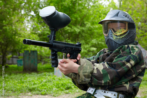 Photo: Paintball player in camouflage uniform and protective mask Paintball player in camouflage uniform and protective mask