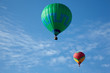 Hot air balloons with people fly in the blue sky.