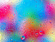 Wasserspritzer auf einer Scheibe mit buntem Hintergrund