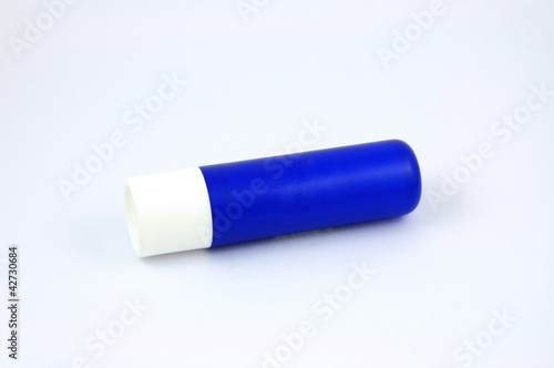 Photo: Blue tube of lip balm isolated on white background Blue tube of lip balm isolated on white background