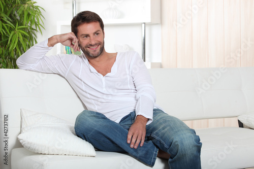 Photo: man sitting on sofa man sitting on sofa