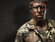 Photo: young soldier with camouflage paint looking very serious against young soldier with camouflage paint looking very serious against
