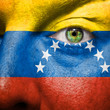 Flag painted on face with green eye to show venezuela support