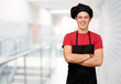 portrait of young cook man wearing uniform and smiling against a