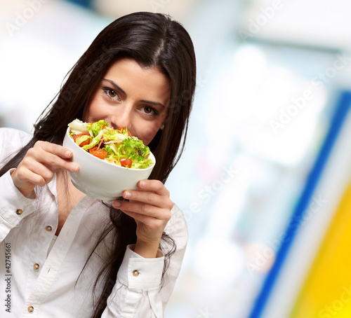 Foto: portrait of young woman holding a fresh salad indoor portrait of young woman holding a fresh salad indoor