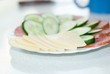 Dish with cut sausage, cheese and a cucumber