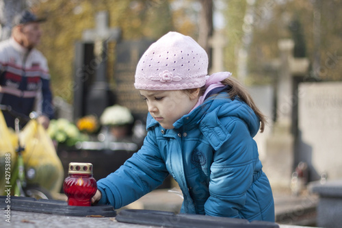 Photo: Girl mourning at the grave on cemetery in Warsaw Girl mourning at the grave on cemetery in Warsaw