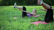 Two women doing sit ups in a park, tracking shot