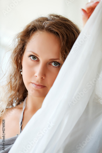 Photo: Sad beautiful woman behind a tulle Sad beautiful woman behind a tulle