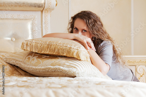 Foto: Beautiful woman in a bedroom Beautiful woman in a bedroom