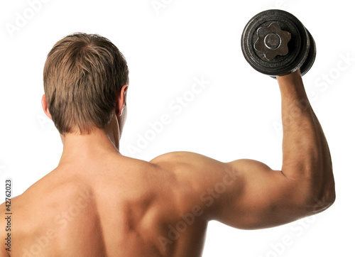 Photo: Muscular young man lifting a dumbbell, rear view Muscular young man lifting a dumbbell, rear view