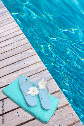 Photo: serviette et tongs sur margelle de piscine serviette et tongs sur margelle de piscine