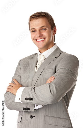 Photo: Young smiling man standing with arms crossed Young smiling man standing with arms crossed