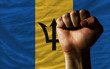 Hard fist in front of barbados flag symbolizing power