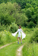 Photo: woman in white dress on green rural road woman in white dress on green rural road