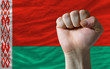 Hard fist in front of belarus flag symbolizing power