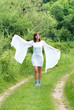 Photo: woman in white dress on green rural road woman in white dress on green rural road