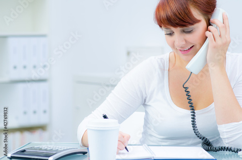 Foto: junge frau am servicetelefon nimmt eine bestellung an junge frau am servicetelefon nimmt eine bestellung an