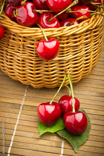 Foto: Delicious sweet cherry fruits in wicker basket Delicious sweet cherry fruits in wicker basket