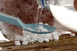Schüßlersalze im Plastiklöffel in Wasser aufgelöst