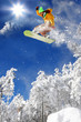 Snowboarder jumping against blue sky