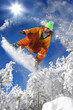 Snowboarder jumping against blue sky