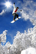 Snowboarder jumping against blue sky