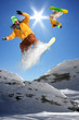 Snowboarders jumping against blue sky