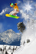 Snowboarder jumping against blue sky