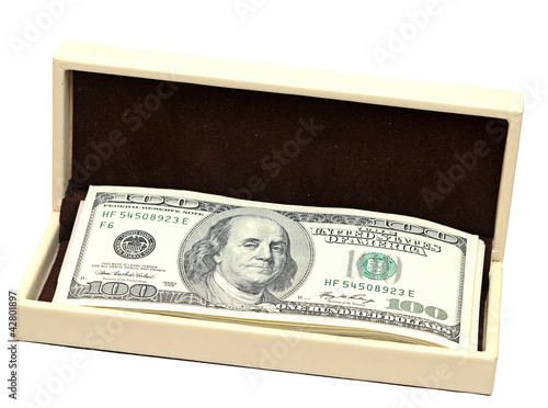 Photo: pile dollars in yellow gift box on white pile dollars in yellow gift box on white