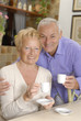 Pareja de señores bebiendo café en una cocina.