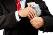 Businessman putting money in his pocket.