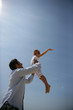 Father lifting his daughter up into the sky