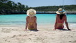 Young female friends sitting on the beach, dolly shot