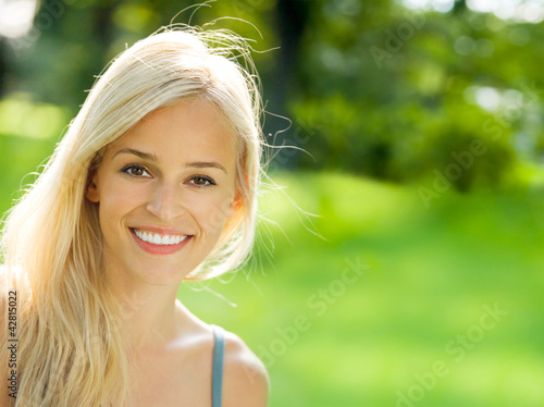 Photo: Smiling young beautiful woman, outdoors Smiling young beautiful woman, outdoors