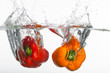 Two clear peppers is thrown into clean water.