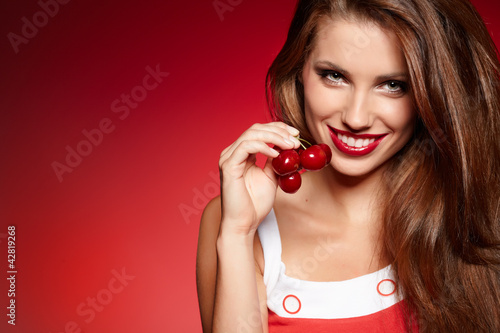 Photo: picture of cherry and lips over red background picture of cherry and lips over red background
